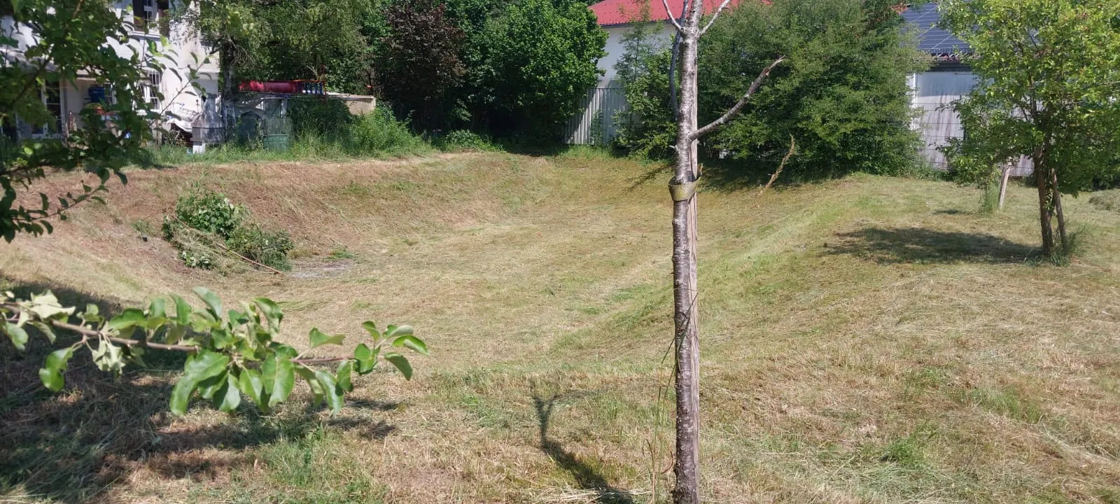 Frisch gemähte, abschüssige Wiesenmulde – saubere Grünpflege in schwierigem Gelände
